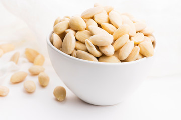 Bowl of almonds on a white background