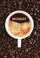 Monday text concept. Freshly brewed coffee in a cup with coffee beans.