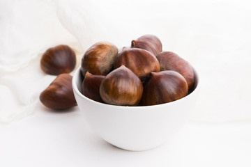 Bowl of chestnuts on a white background