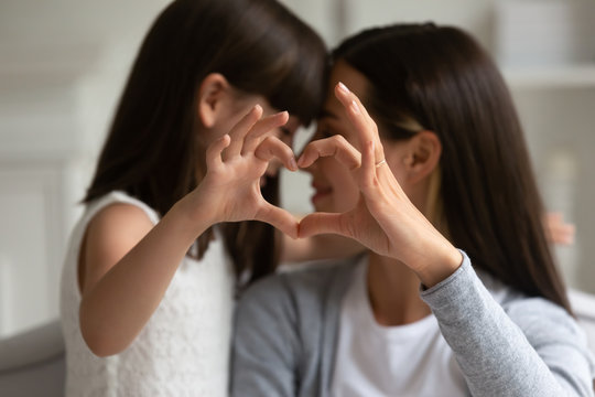 Mothers and daughters fingers showing heart symbol of love