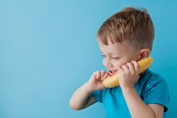 Little Boy tries to speak by means of a banana instead of phone.