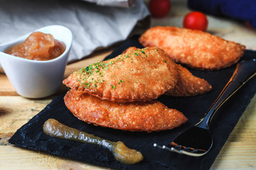 Four hand pie homemade with tomato and egg accompanied with applesauce and tomatoes cherry. Front view, no people