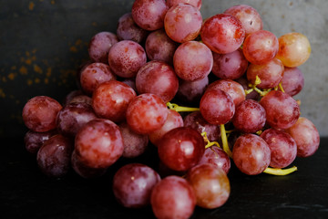 Pink grapes on dark background. 