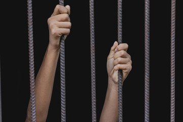 child holding a steel cage in old iron bar. children prison and prisoner concept