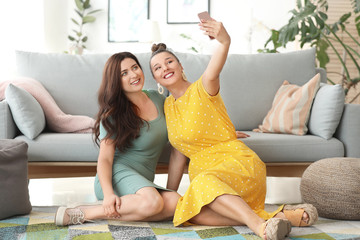 Happy body positive women taking selfie at home