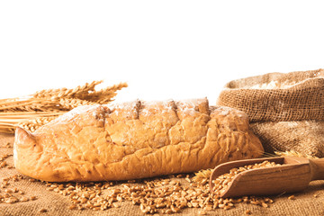 Fresh bread with grains and flour on table
