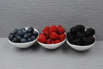Fresh Berries - Blueberries, Raspberries, Blackberries on a gray backgroud