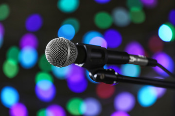 Fototapeta na wymiar Microphone on dark background with defocused lights