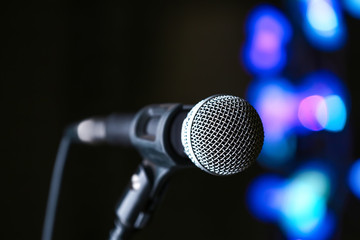 Fototapeta na wymiar Microphone on dark background with defocused lights