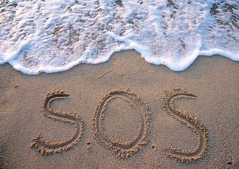 SOS - word drawn on the sand beach - obrazy, fototapety, plakaty