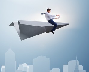 Obraz premium Businessman flying on paper plane in business concept