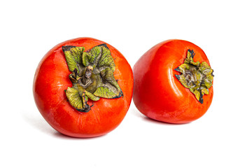 Two juicy and sweet persimmon fruits isolated on white background