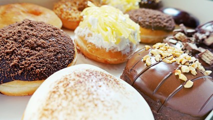 Close up Group of Glazed donuts on white paper box tasty multiple assorted donut twelve 12 pieces in box.