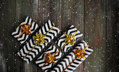 Fototapeta premium Christmas gifts with golden ribbons and bows on wooden background.