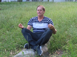 Naklejka na ściany i meble man sitting on grass
