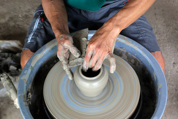 hands making pottery on pottery wheel