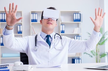 Young doctor with vr virtual reality headset working in the offi