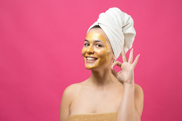 Beauty portrait of woman in white towel on head with gold nourishing mask on face. Skincare cleansing eco organic cosmetic spa relax concept.