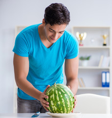Fototapeta premium Man eating watermelon at home