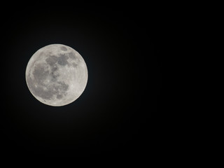 December full moon against pitch black sky