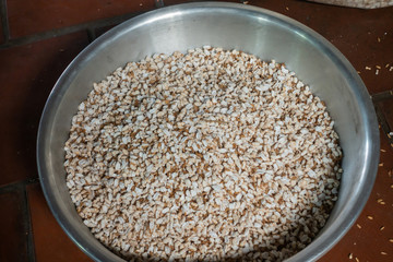 Cai Be, Mekong Deltal, Vietnam - March 13, 2019: Closeup of brown-white popped rice kernels in metal basin.