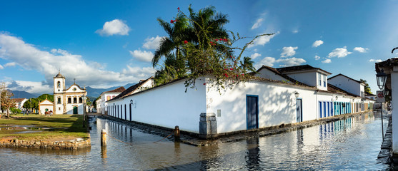 Flooded streets in the historic center of paraty with old church in the background of catholic religion in Rio de Janeiro, Brazil, sail boat