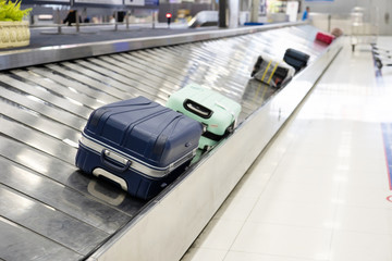 Suitcase on luggage conveyor belt at airport