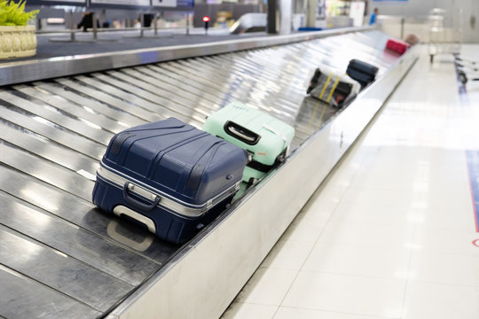 Suitcase On Luggage Conveyor Belt At Airport