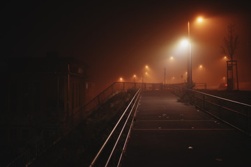 Fototapeta na wymiar dramatic light on a bridge during a foggy night in Leipzig, Germany