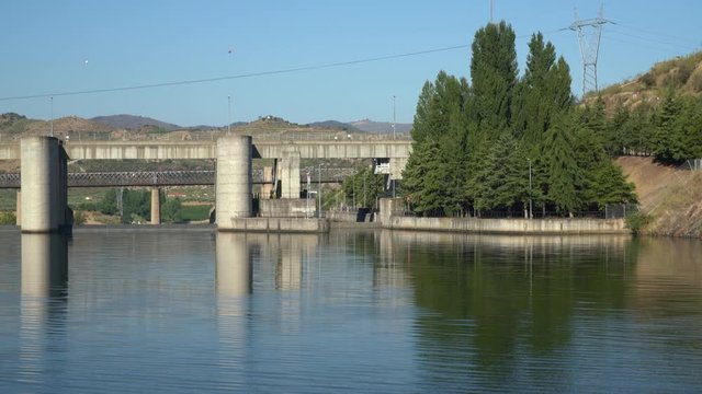 Barragem do Pocinho dam in the distance as a river cruise boat on the Douro starts to approach the lock