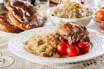 Pork knuckle with fried sauerkraut and tomatoes