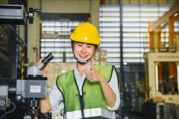 Asian female engineer factory inspection with robot ai machine assist production engineer in industry She wears a helmet female working metalwork control in industrial In a plastic factory for car