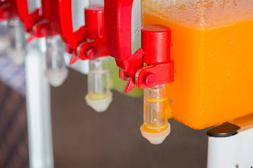 Orange juice and water in dispenser and glasses