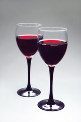 Two glasses with red wine on gray