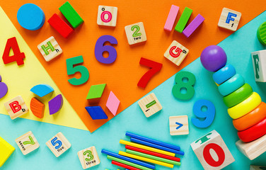Wooden kids toys on colourful paper. Educational toys blocks, pyramid, pencils, numbers, train....