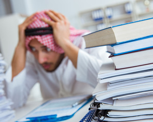 Arab businessman working in the office doing paperwork with a pi