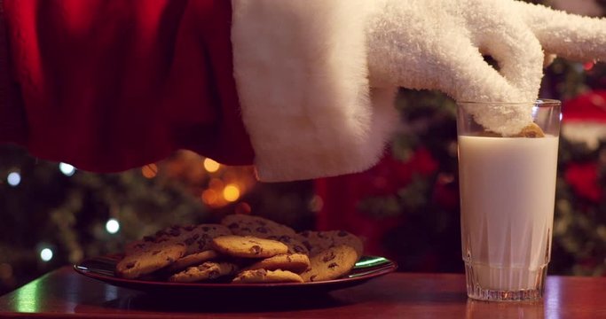 Santa dunking cookies in milk in front of the Christmas tree - shot on RED