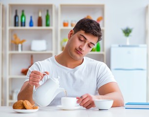 Man falling asleep during his breakfast after overtime work
