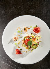 Olivier salad with crab meat and shrimps on white plate