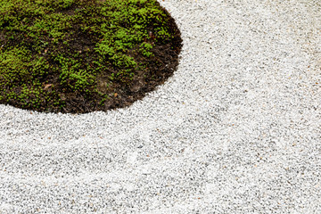 The garden floor consists of small stones and green grass.