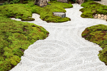The garden floor consists of small stones and green grass.