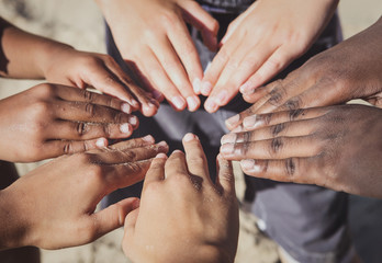 Multicultural childrens hands in a circle.