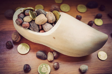 Natural wooden shoe for St Nicholas day with nuts and chocolate coins
