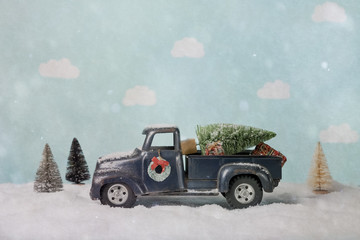 Bottle brush Christmas tree on a toy truck in a winter scene