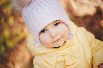 a little girl in a warm hat on his head smiled. the concept of childhood, health, IVF, cold time