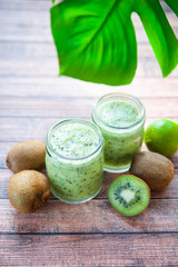 Kiwi smoothies in glass cups on a wooden table