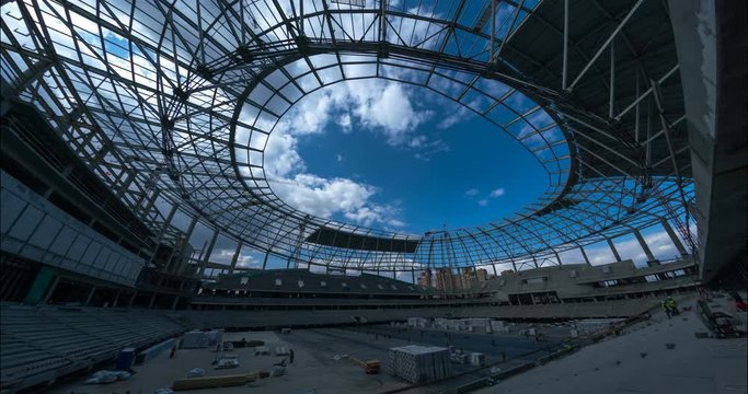 High-altitude cranes, metal girders of the roof, concrete tribunes and builders - this is the construction of a new stadium. Time-lapse