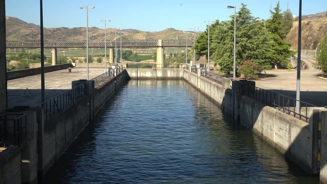 Cruise river boat starts to enter the lock of Barragem do Pocinho dam on the Douro ready for the descent to the lower level of the river