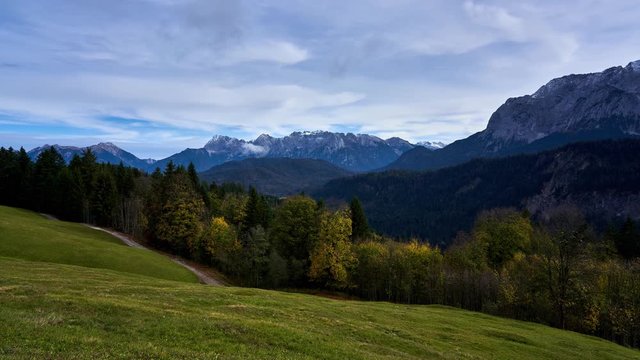 slow panning timelapse from Eckbauer near Garmisch-Partenkirchen of the snow capped Wetterstein mountains in autumn in the alps. Germany