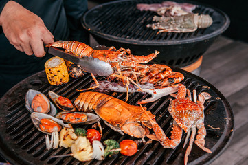 Lobster and mix seafood barbecue cokking on grill - 305344904